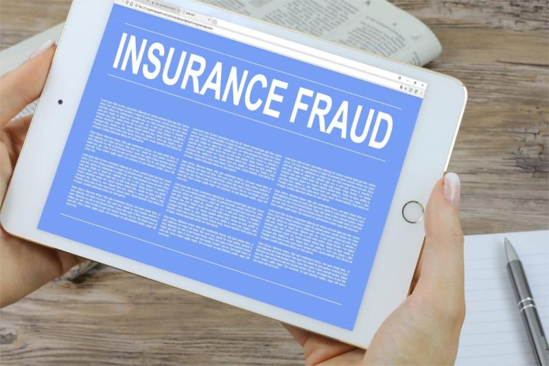 woman holding a tablet with insurance fraud written